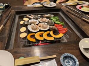 囲炉裏で焼かれる海鮮や野菜